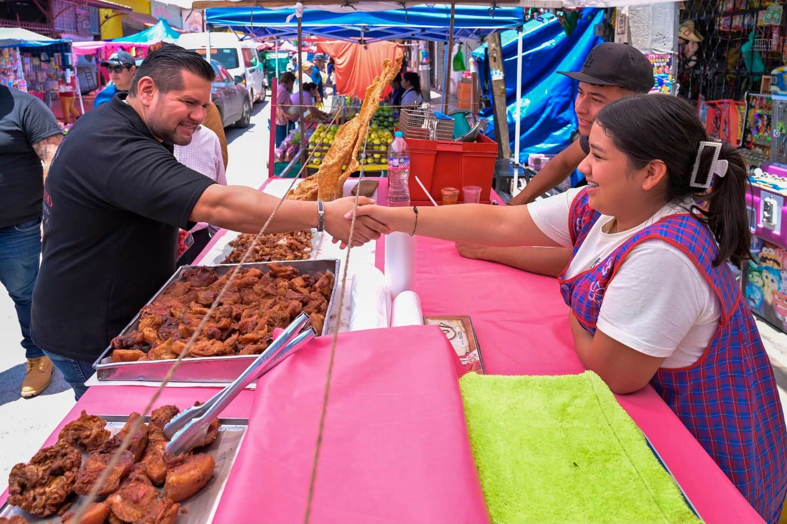 Samuel Ríos saludando a una comerciante en el tianguis